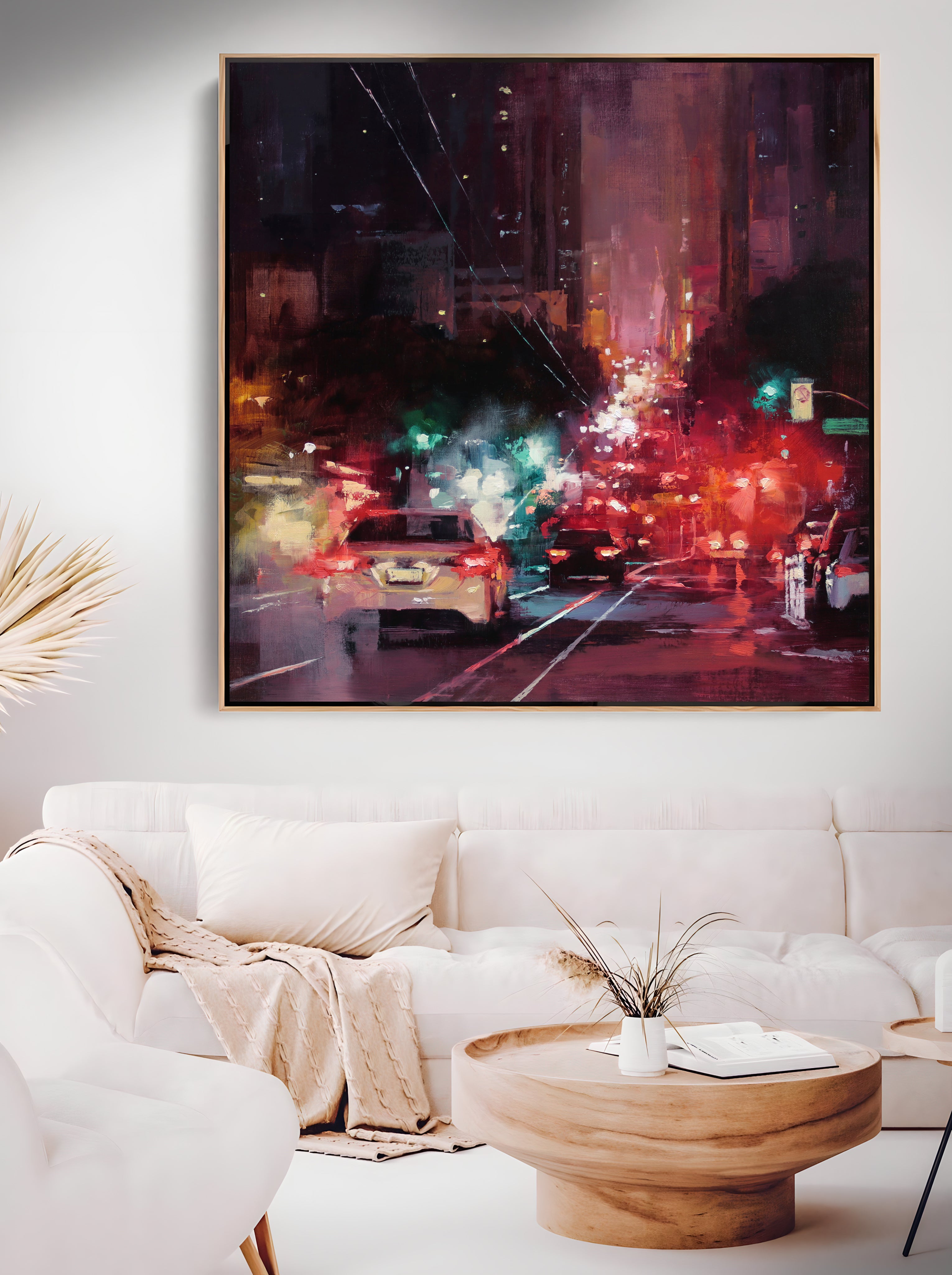 a living room with a white couch and a painting on the wall