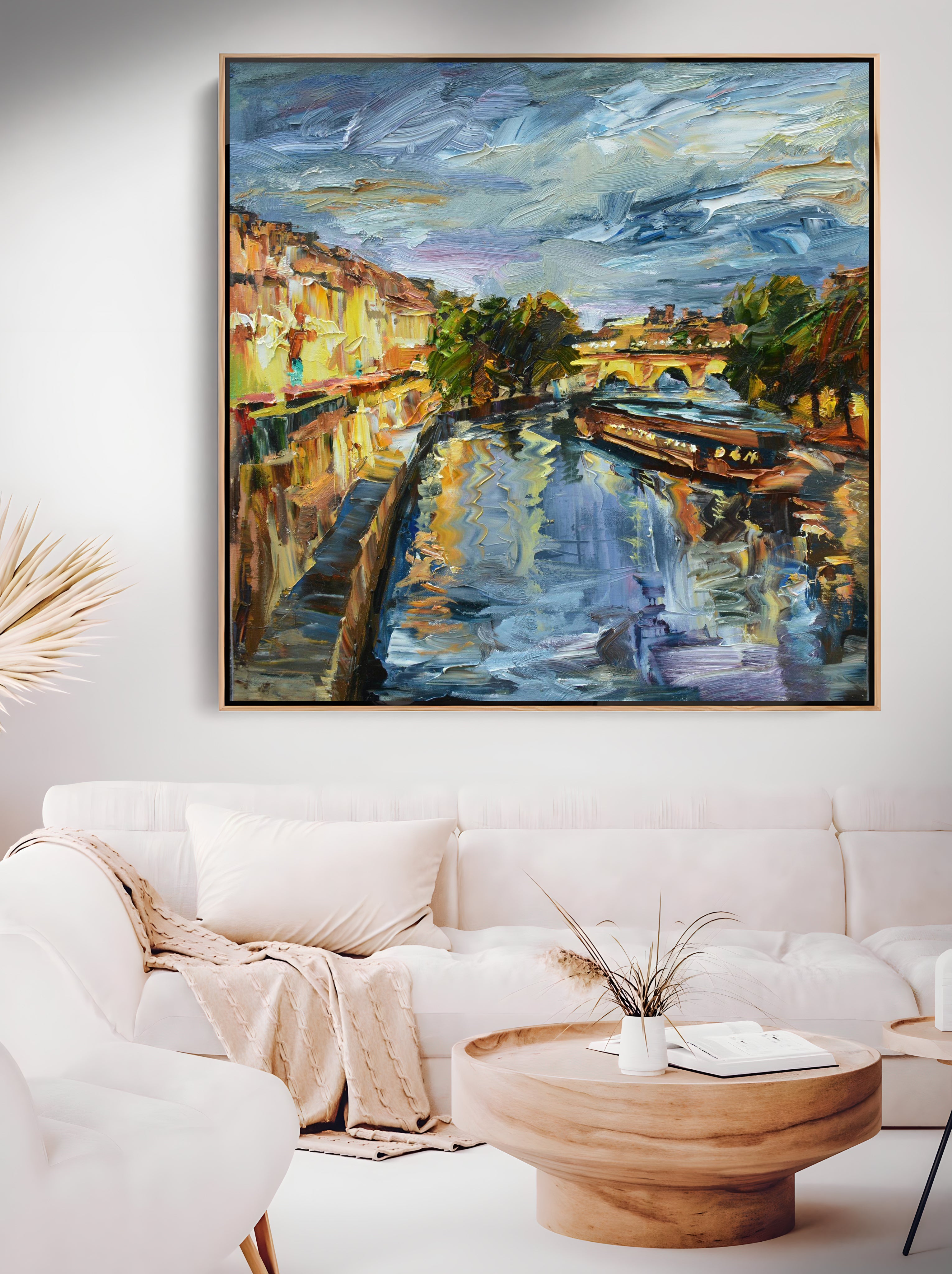 a living room with a white couch and a painting on the wall