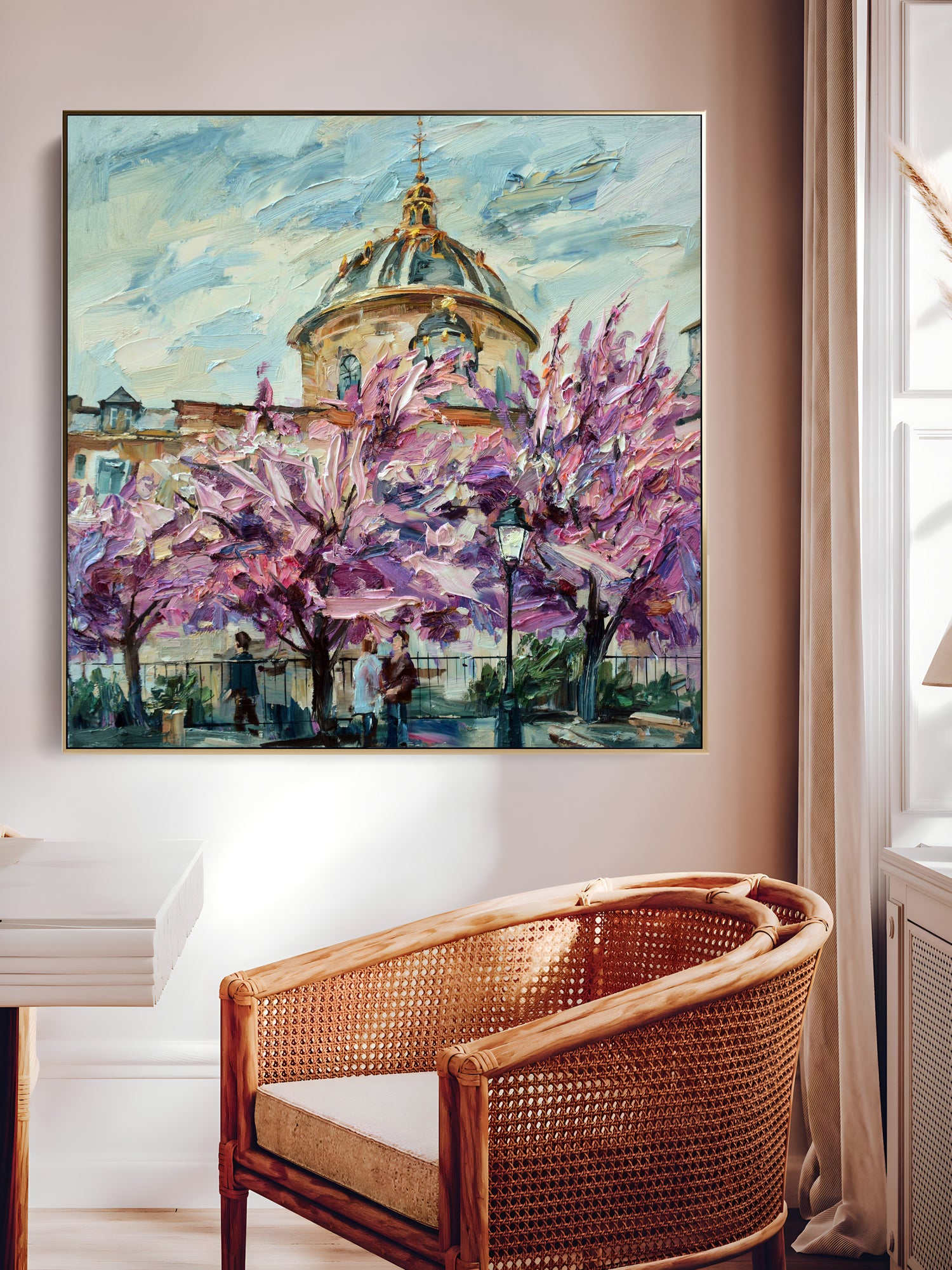 a painting hanging on a wall above a wicker chair