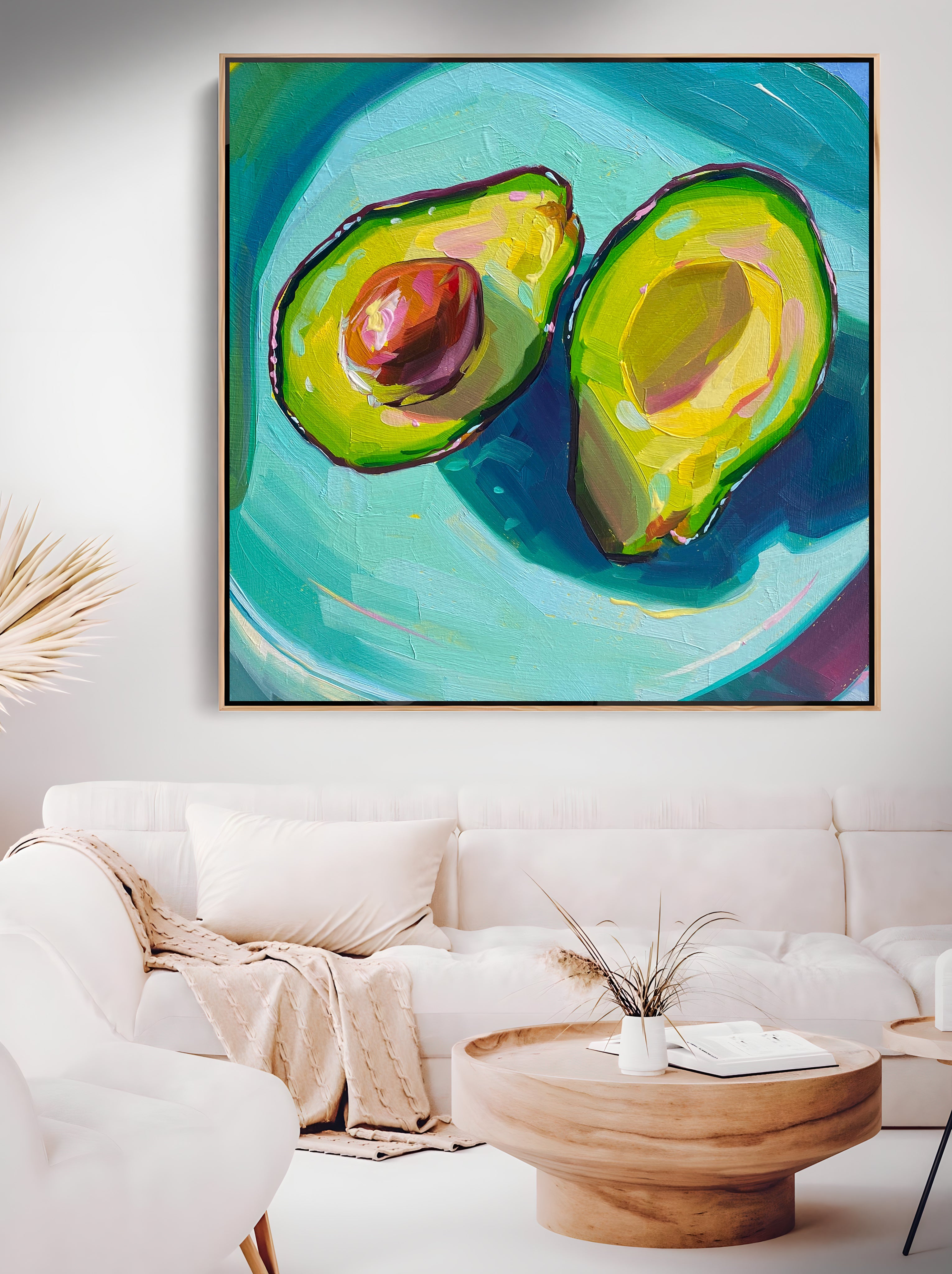 a painting of an avocado on a wall above a white couch