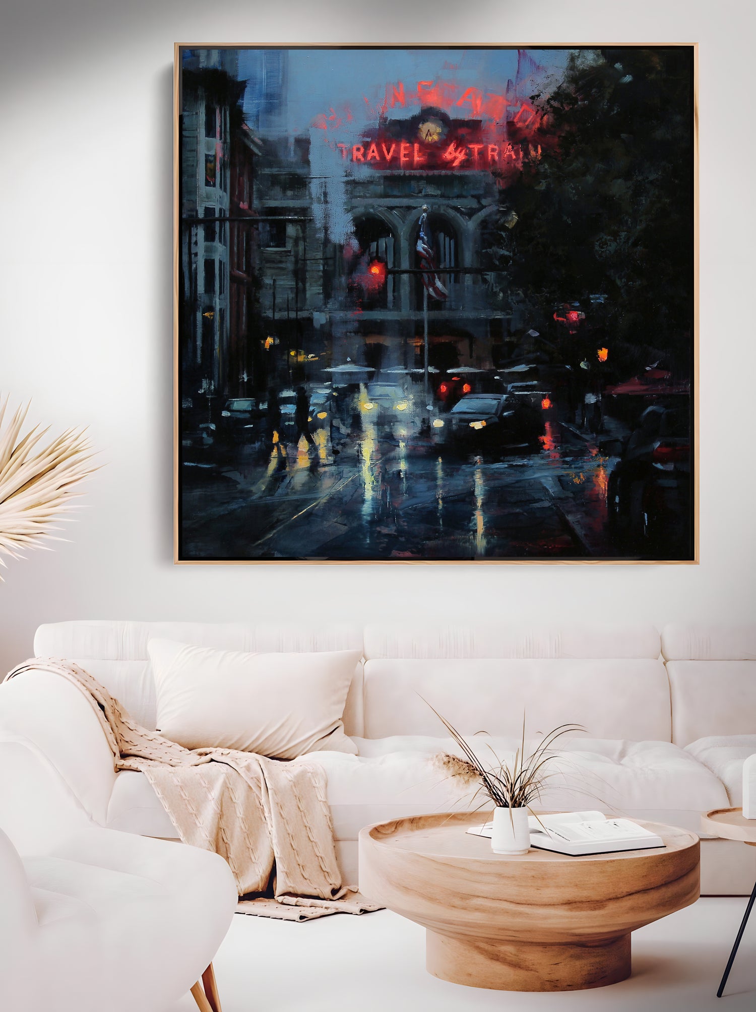 a living room with a white couch and a painting on the wall