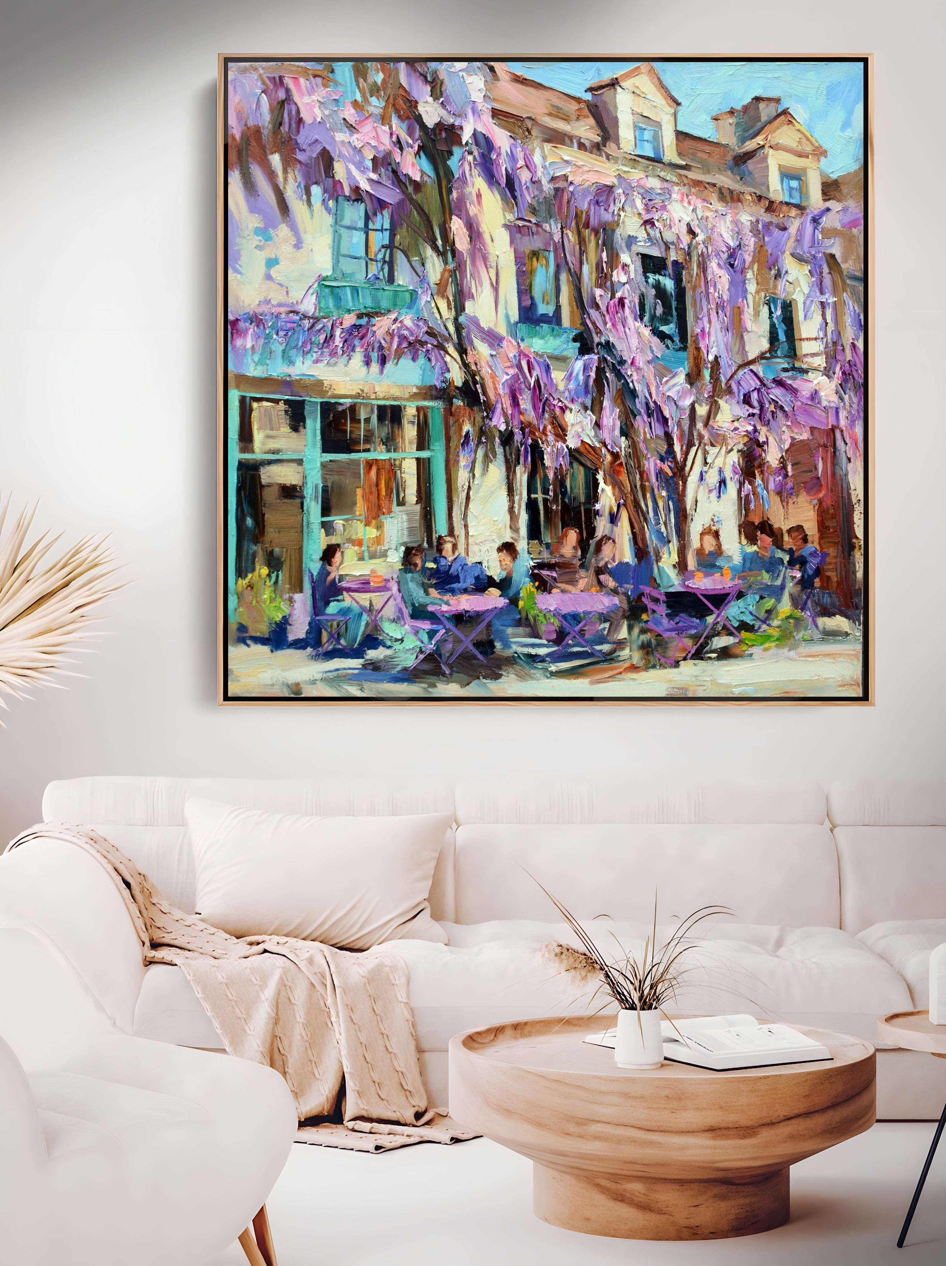 a living room with a white couch and a painting on the wall