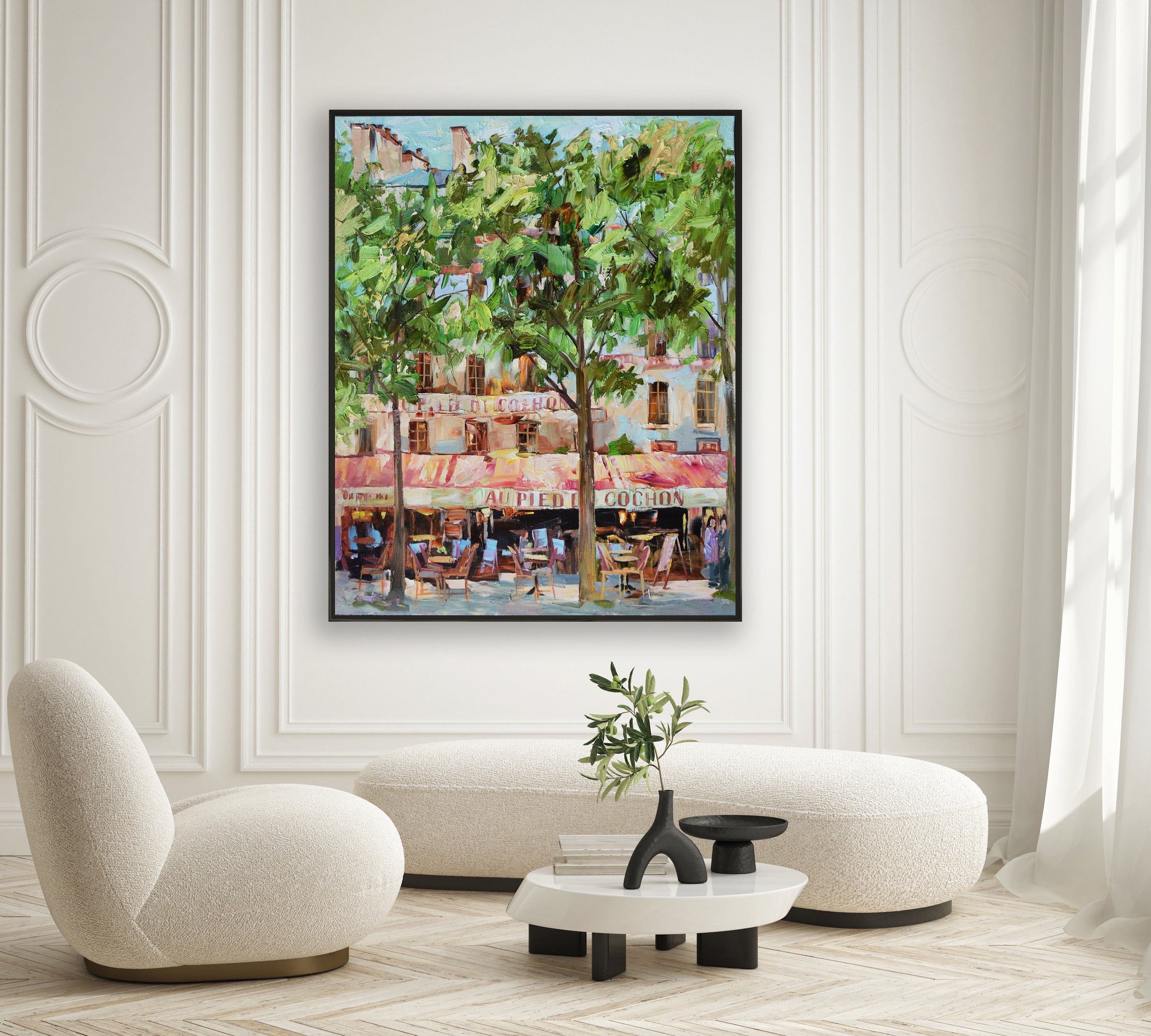 a living room with white furniture and a painting on the wall