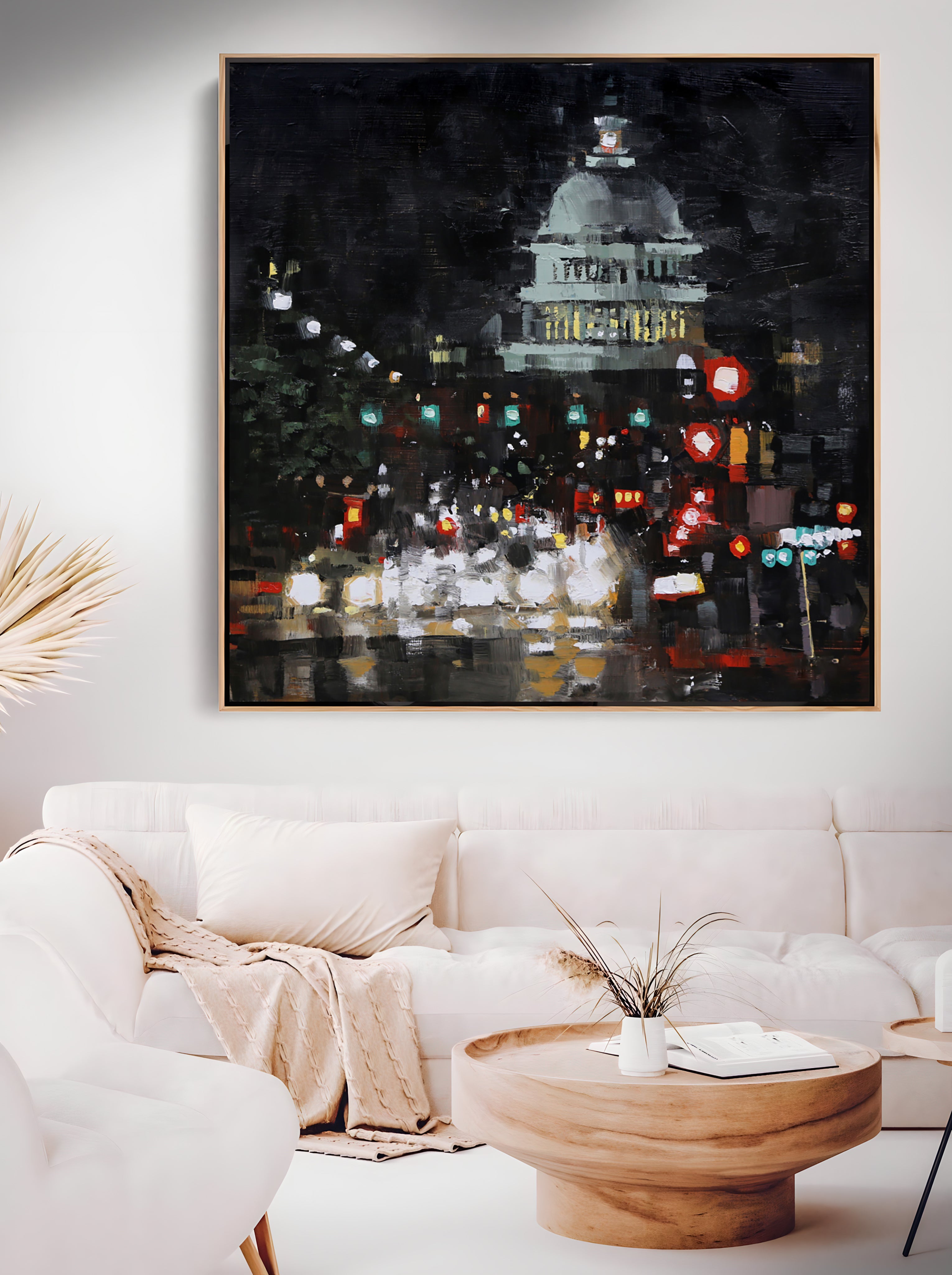 a living room with a white couch and a painting on the wall