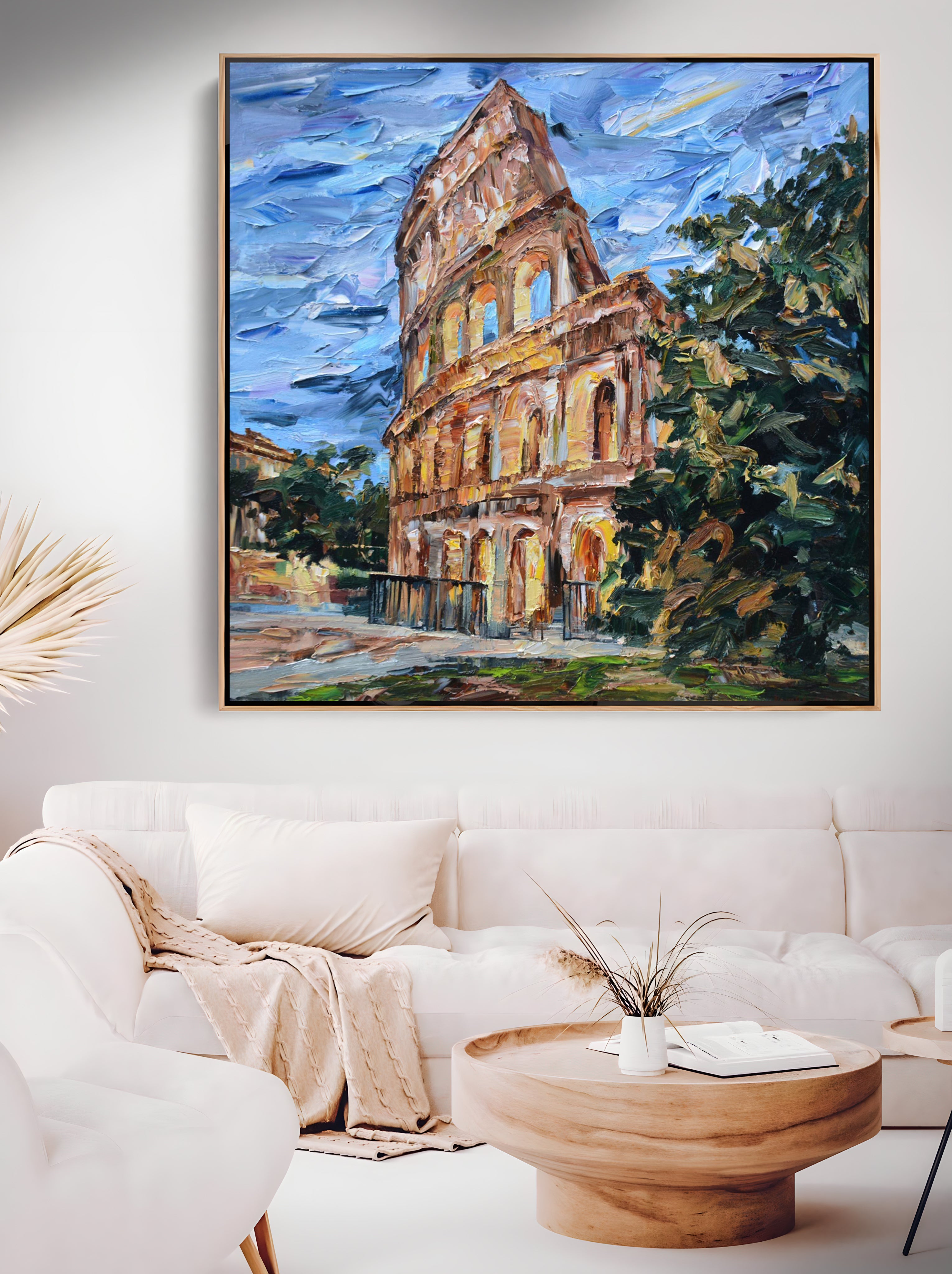 a living room with a white couch and a painting on the wall